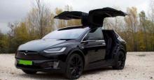 zöld rendszámos Tesla Model X szemből, nyitott ajtókkal